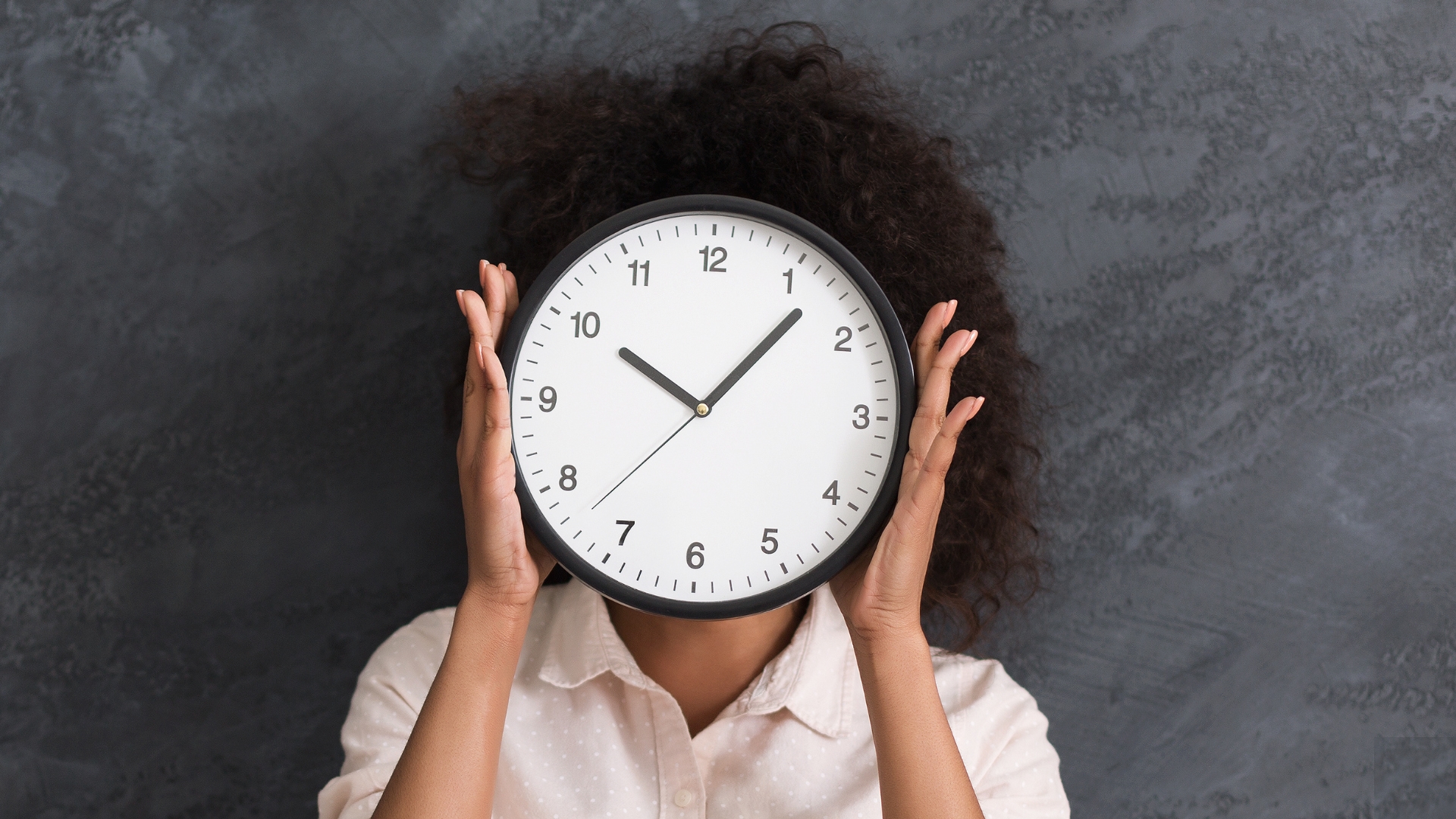 woman practicing time management holding a clock